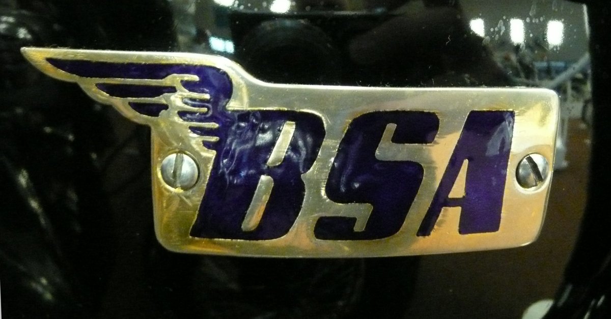 Post-war BSA winged tank badge: a brass plate with a feathered wing and italic BSA letters in blue enamel