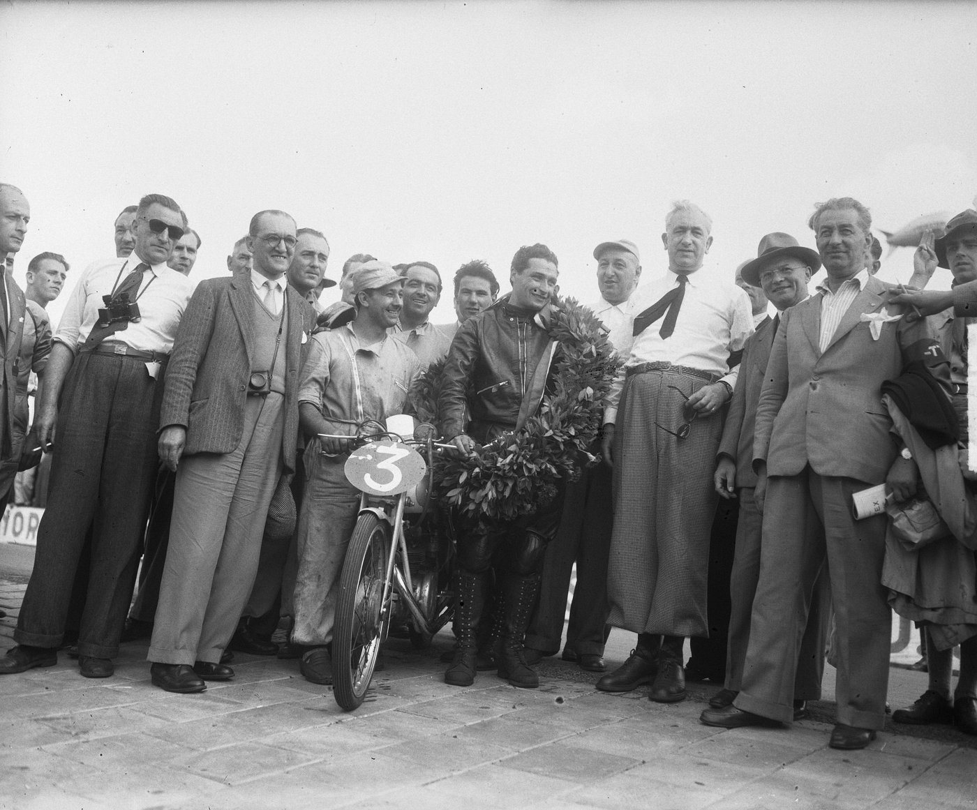 Bruno Ruffo with his Mondial and a winner's wreath at Assen, 1950, surrounded by officials