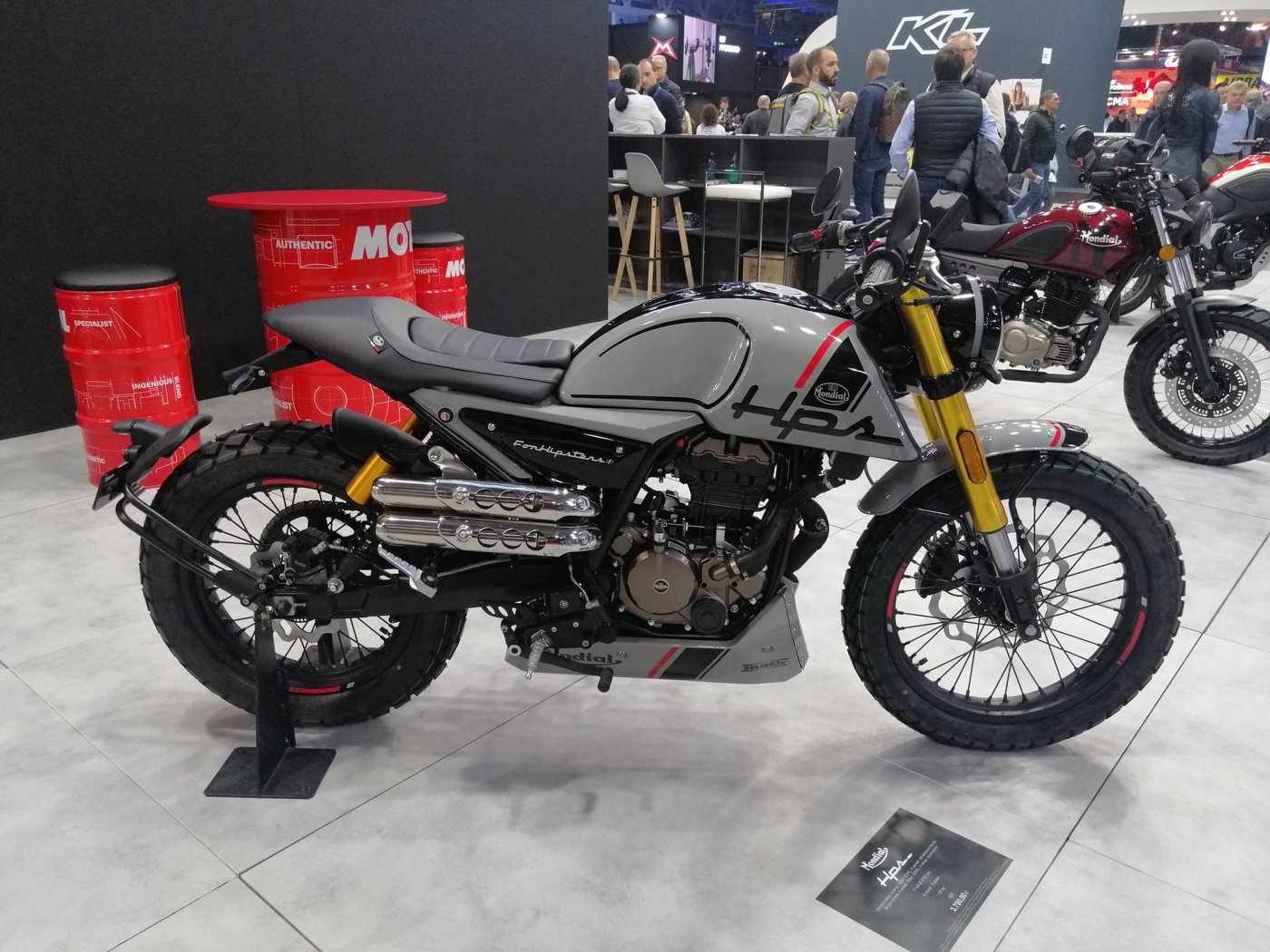 Grey 2025 FB Mondial HPS scrambler on a show stand with a small monochrome F.B Mondial oval on its tank