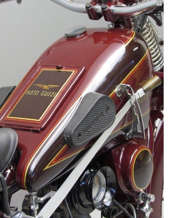 Maroon saddle tank of a 1932 Moto Guzzi Sport 15 with a gold eagle and MOTO GUZZI lettering inside a lined rectangular panel