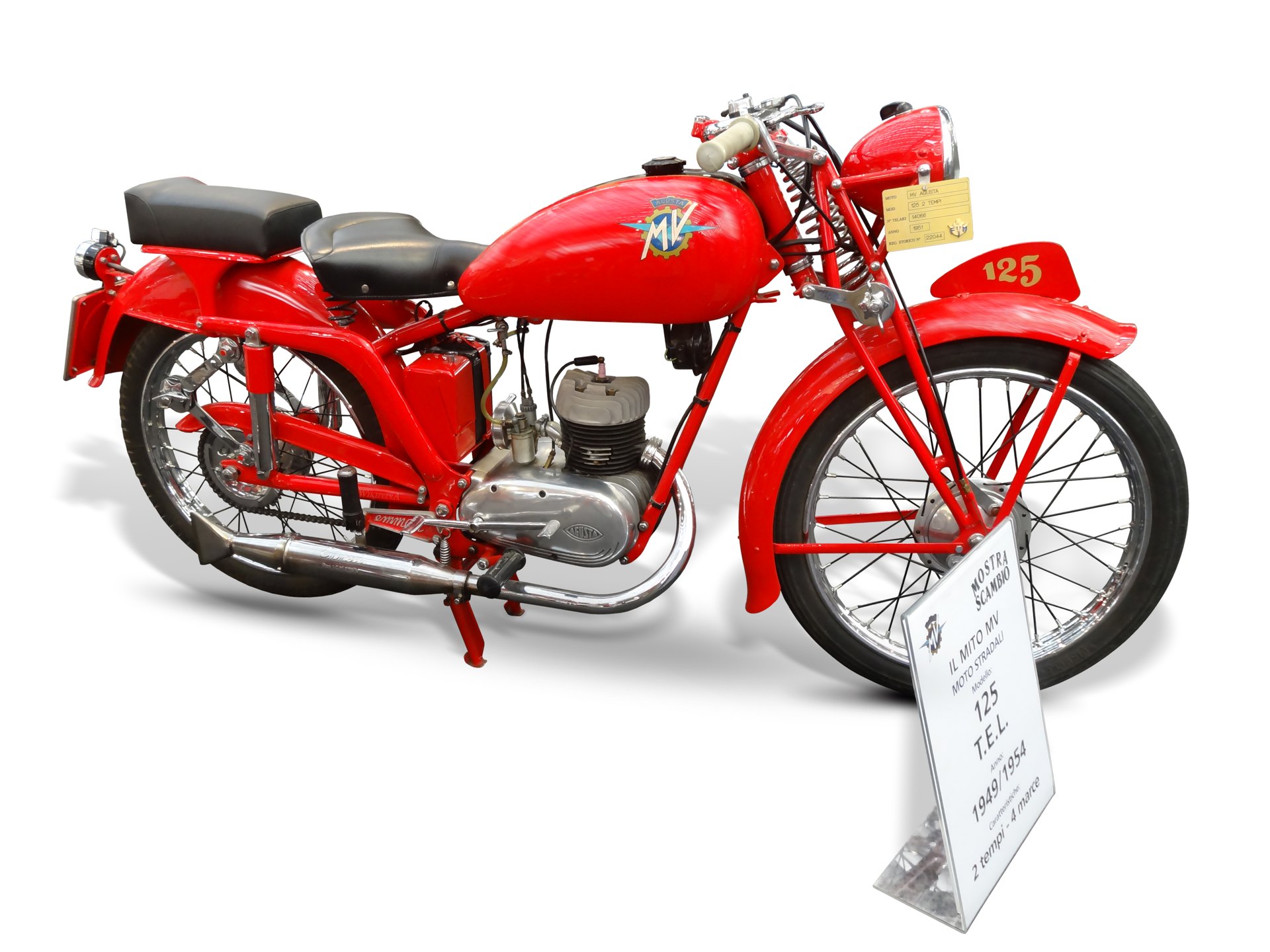 A red MV Agusta 125 TEL of 1949 with a museum placard, its tank carrying the crest with a gold cog, blue centre, pale blue arrow wings and a white MV
