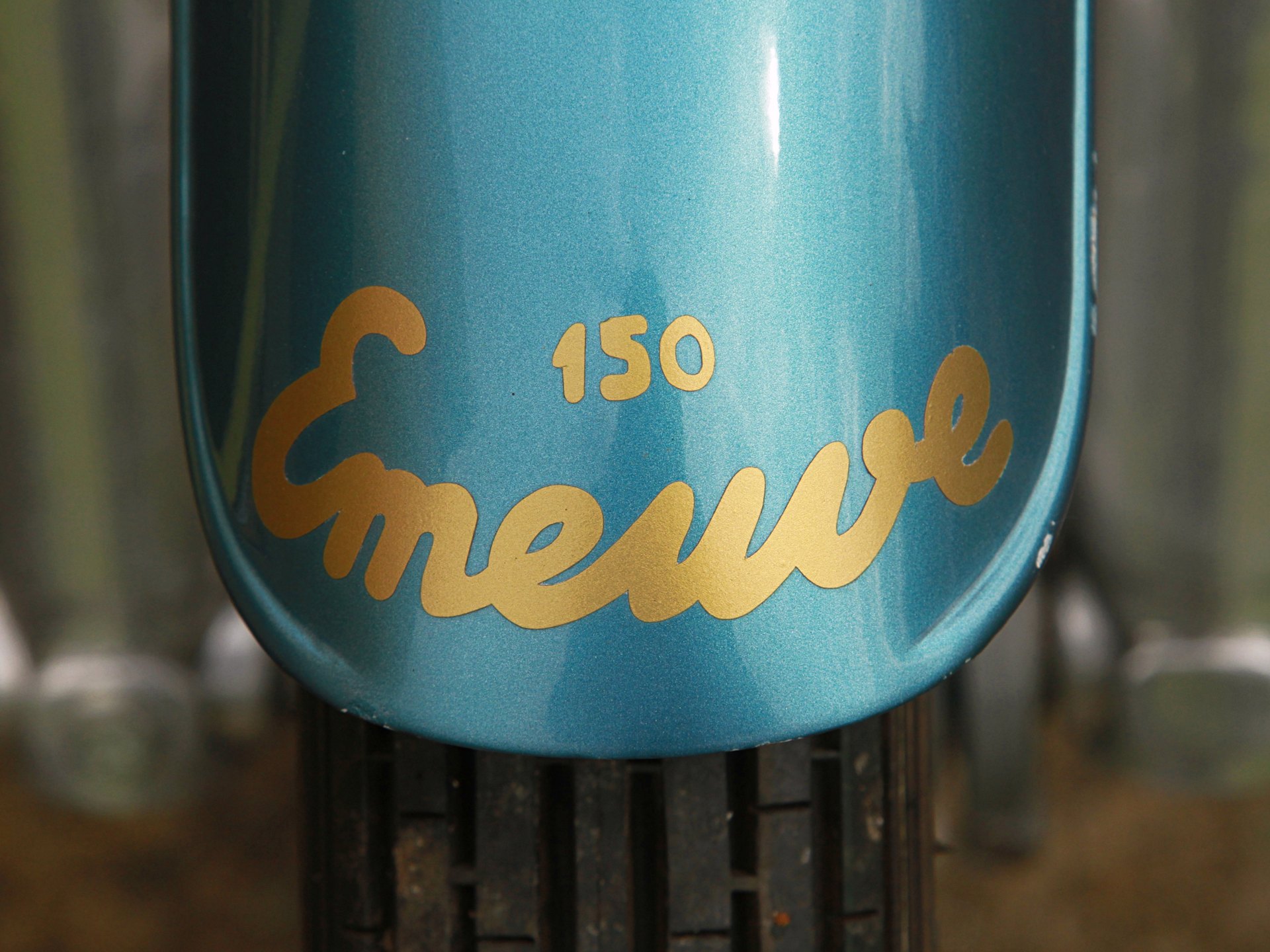 Teal front mudguard with the gold script word Emeuve and the number 150