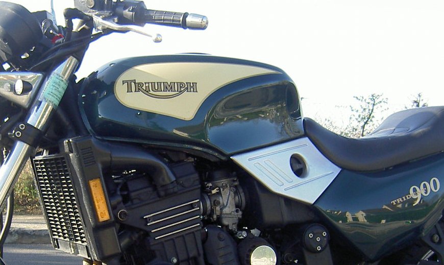 Dark green and cream tank of a 1992 Triumph Trident 900 with the Hinckley-era TRIUMPH wordmark painted on the cream panel
